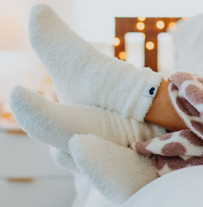 Close-up of feet in cozy Little Giraffe socks with a blurred background