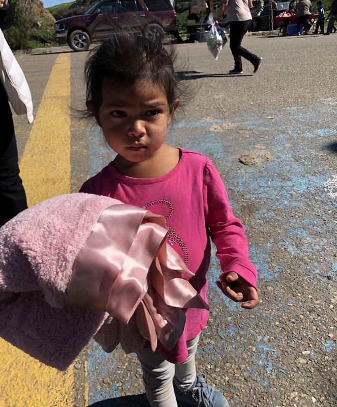 Little girl holding pink baby blanket