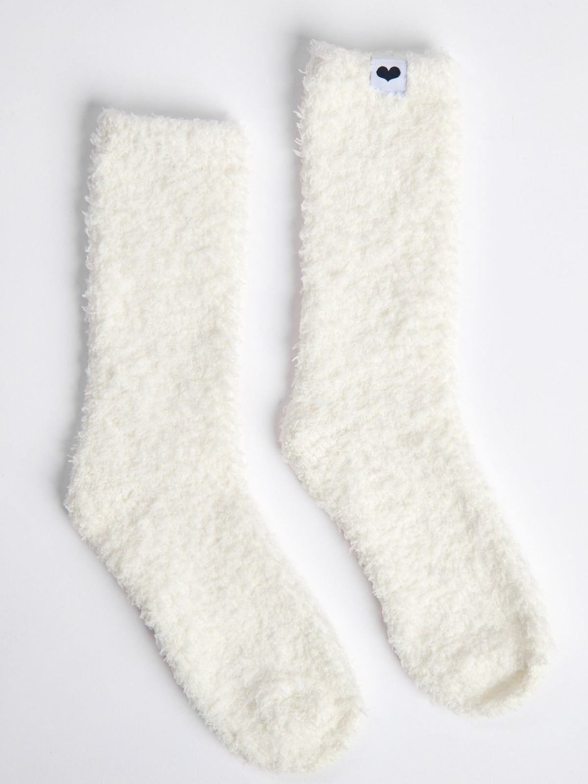 Pair of white fuzzy Little Giraffe socks on a light gray background