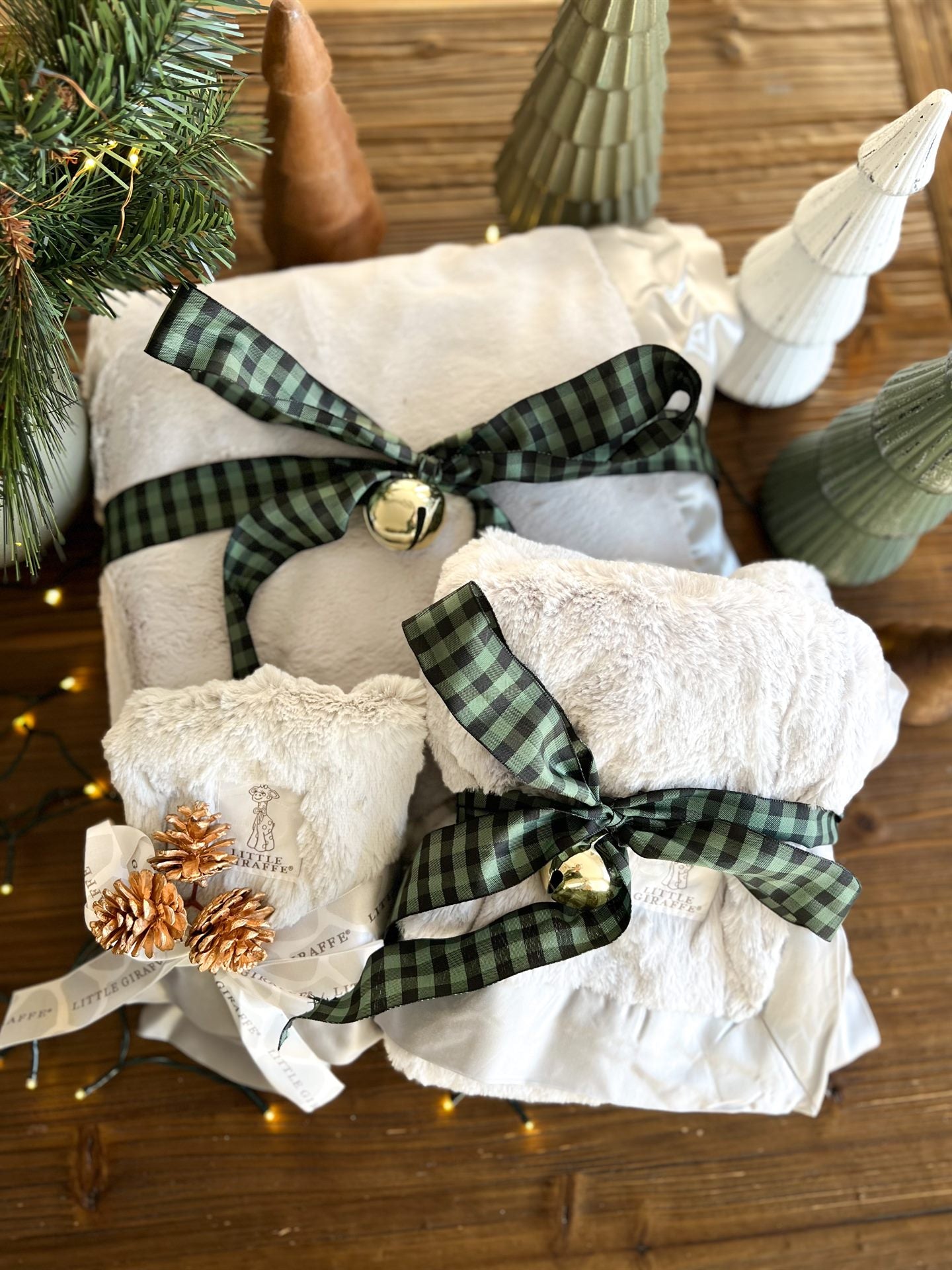 Little Giraffe blankets tied with plaid ribbon and pinecones