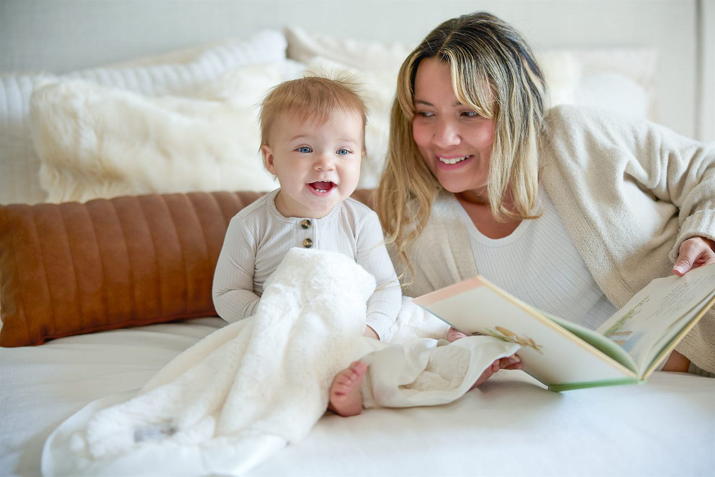 Mother reading to her baby on a cream Luxe blanket